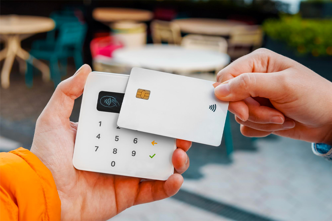 Persona che poggia la propria carta sul POS per pagare